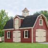 Two story Dutch Barn with red siding, light doors and second level door in dormer and cupola