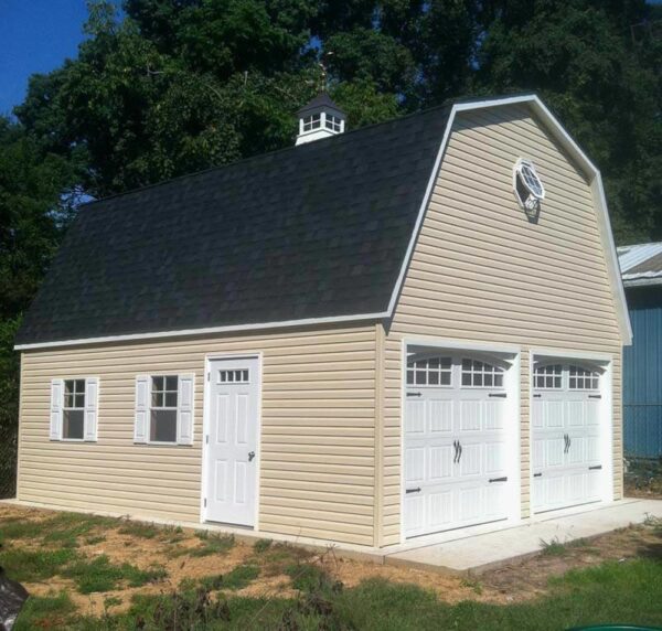 Two story Dutch Barn with tan siding and white doors