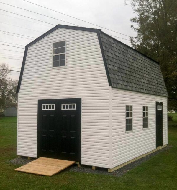 Two story Dutch Barn with white siding and dark doors