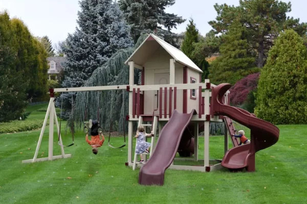 Young boy on a maroon swingset